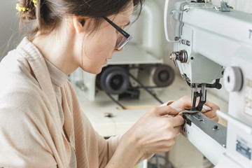 Woman stitching leather using a sewing machine