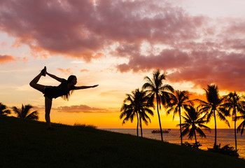 Yoga in the park. Female exercising outdoors at unset. 