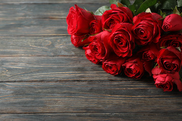 Bouquet red roses on wooden background, space for text