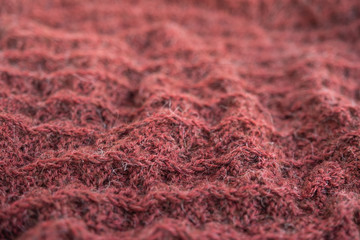 Knitted woolen texture of coral color.