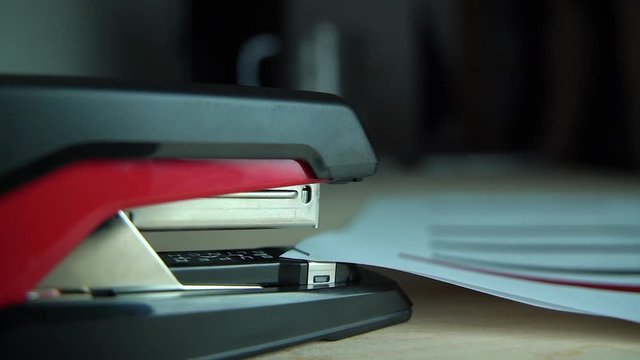 Stapling paper, closeup of man hands in office
