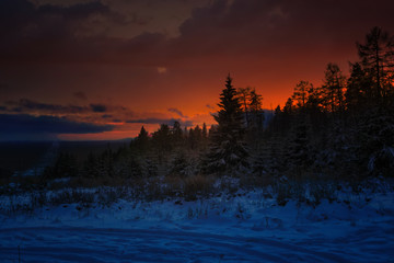Colorful sunset in the winter forest. Beautiful winter landscape in the mountains. Sunrise.