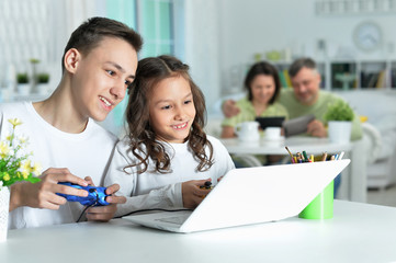 portrait of boy and girl playing video game on laptop