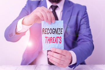 Conceptual hand writing showing Recognize Threats. Concept meaning potential to cause serious harm to a computer system Man holds empty paper with copy space in front of him Space
