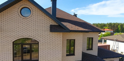 Bituminous tile for a roof. House with a roof from a bituminous tile. a roof from a bituminous tile. Moder