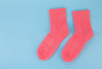 Pink socks on a blue background. Women's socks on a colored background
