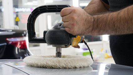 The man polishes the cars from body scratches, car service, autoshop, washing, polishing.