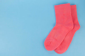 Pink socks on a blue background. Womens socks on a colored background