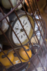 Old school retro vintage alarm clocks tracking time trapped in a bird cage rusty metal iron nice soft shadows slow dying feeling vibe historical objects hidden clock Prison locked away Chernobyl