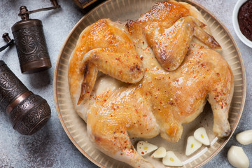 Close-up of pan fried chicken tapaka served on a beige plate, studio shot, view from above