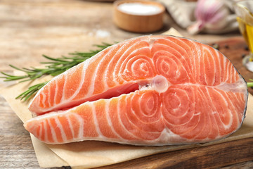 Fresh raw salmon with rosemary on wooden table. Fish delicacy