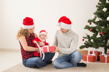 Happy couple with baby celebrating Christmas together at home.