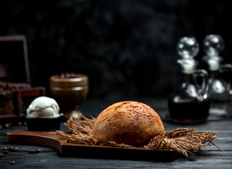 airy brown bread on a wooden board and a scoop of ice cream