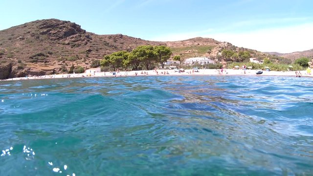 Spain, Mediterranean beach coastline in summer vacations, camera moves from underwater to above sea surface, Costa Brava, Catalonia, Cala Joncols