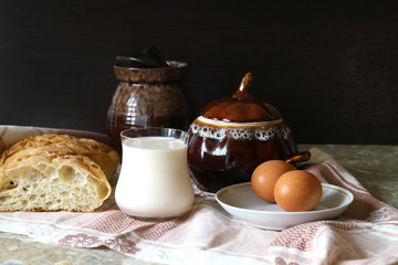 Food bread, milk in a glass Cup and eggs on the table on the tablecloth