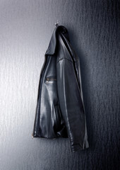 scharze Lederjacke hängt an einem haken isoliert