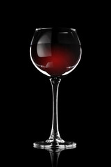 A glass of red wine on a black background in a contrasting light