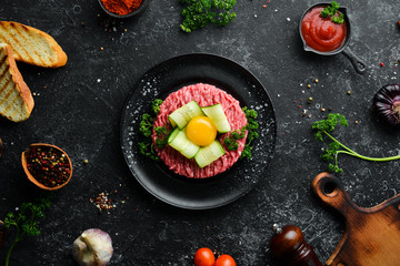 Beef tartare with egg yolk. Traditional cuisine. Top view. Free space for your text.