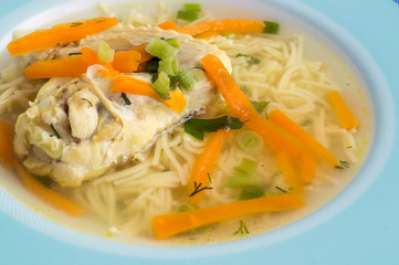 chicken soup with vegetables and noodles. on a dark background, close-up
