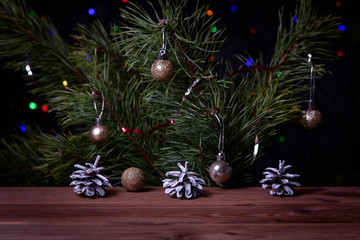 Christmas, decoration on a wooden table. Christmas pine cones and golden Christmas balls. Burning candle