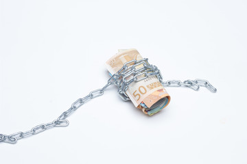Dinero y cadenas, billetes de dinero rodeados de cadenas, metáfora de la vida en la que vivimos,...
