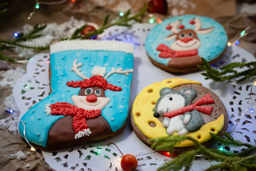 Fototapeta na wymiar Assortment of Christmas cookies on openwork napkin. Round gingerbread cookies with deer and mouse. Christmas decor.