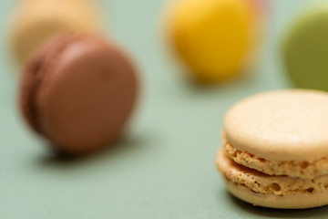 Obraz premium Colored tasty macaroons over a green background