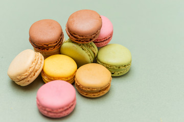 Colored tasty  macaroons over a green background