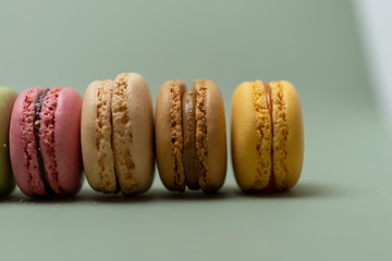 Colored tasty  macaroons over a green background