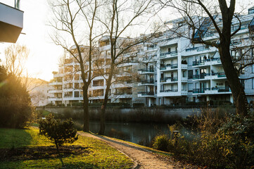 Fototapeta na wymiar Morning view over apartment building condominiums calm lake and cinematic flare
