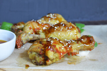 Grilled spicy chicken legs on a black background.Top view. backet chicken on paper