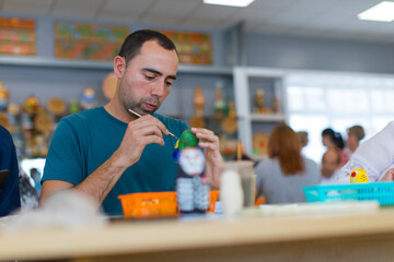 man painting a matrioska doll in russia