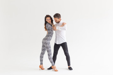 Social dance, kizomba, tango, salsa, people concept - beautiful couple dancing bachata on white...