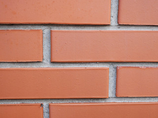 Obraz premium Orange brick wall. Brick with seams. Close-up. brick wall texture background, fence, brick wall, masonry, material, surface, flat, front, view, pattern, abstract, background, design
