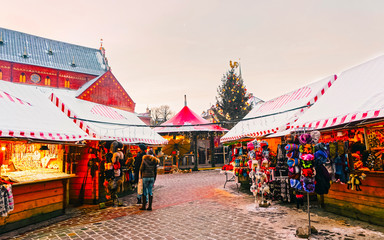 Knitted goods displayed on a Christmas market stall. Old Town of Riga, Latvia. Wool mittens, gloves, socks with hats in winter. Street Xmas and holiday fair in European city. Advent Crafts on Bazaar