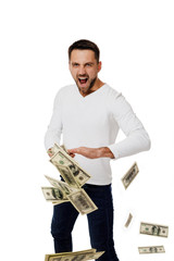 Naklejka premium young man throwing money banknotes at camera isolated on white background