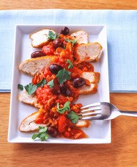 Gebratene Hühnerbrust mit gehackten Tomaten und Oliven