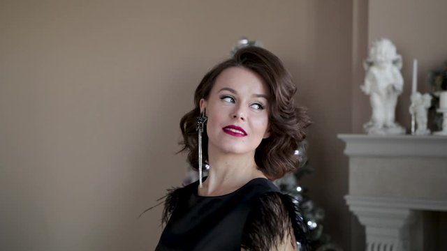 Beautiful sexy girl stroking her hair on the background of Christmas tree, pine. Christmas, new year, holiday, family celebration