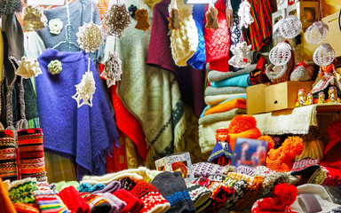 Knitted goods displayed on a Christmas market stall. Old Town of Riga, Latvia. Wool mittens, gloves, socks with hats in winter. Street Xmas and holiday fair in European city. Advent Crafts on Bazaar