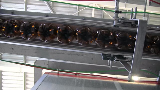 Plastic bottles in production line. Plastic bottles before blowing. Close up of production line of pet bottles.
