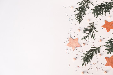 Christmas winter composition. Wooden star, fir branches and sparles on white background. Top view, flat lay
