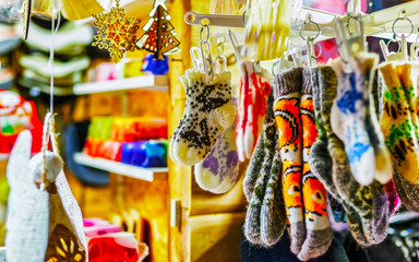Colorful warm gloves and socks at the Christmas Market in Riga, Latvia. Clothes. Wool mittens on stalls in winter. Street Xmas and holiday fair in European town. Advent Decoration with Craft on Bazaar