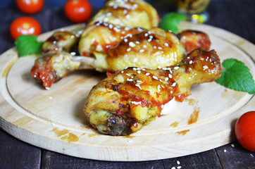 Grilled spicy chicken legs on a black background.Top view. backet chicken on paper