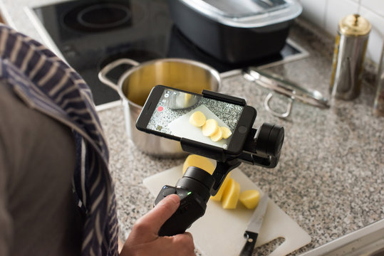 Blogger making smartphone video while cooking