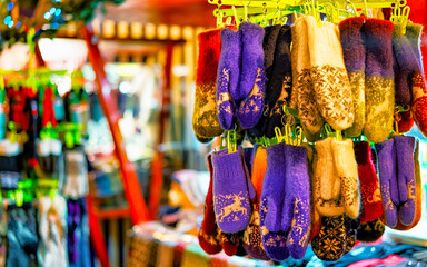 Colorful warm gloves at the Christmas Market in Riga, Latvia. Clothes. Wool mittens on stalls in winter. Street Xmas and holiday fair in European city or town. Advent Decoration with Crafts on Bazaar
