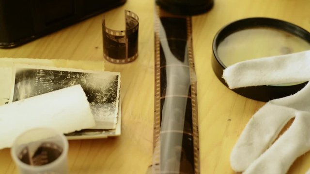 a table of a photographer with negative images, camera and other analog photographic equipment
