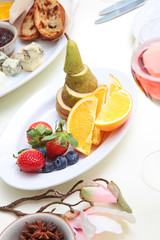 The fruit on the plate and pink champagne on the table set for the holiday. Restaurant.