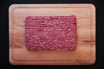 Minced meat on wooden cutting surface. Top view, flatlay