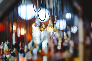 Quartz and other precious stones hung on necklaces in a mineral and beauty shop.