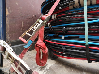 Bunte Kabel auf einer Kabeltrommel mit rotem Spanngurt zur Sicherung auf der Ladefläche eines...